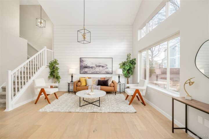 this straight shot in the living room shows the modern furniture with two boucle accent chairs and a faux leather sofa