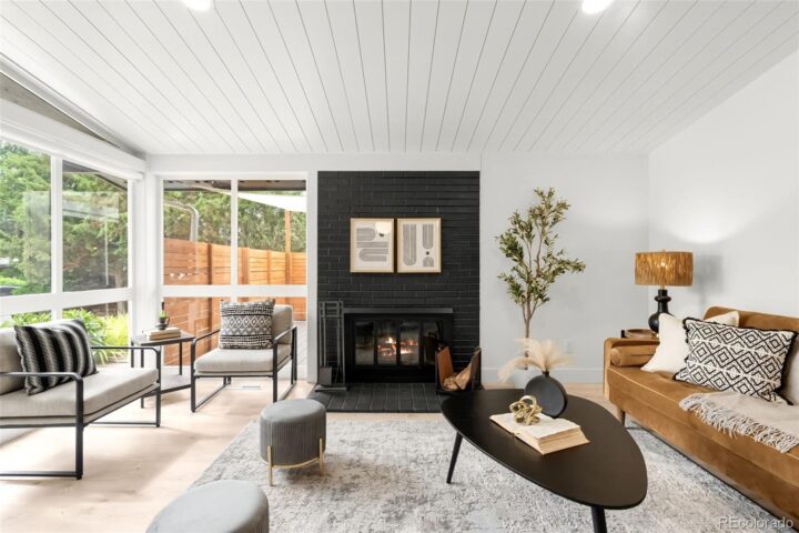 the black fireplace is the main accent in the living room with white walls and modern furniture